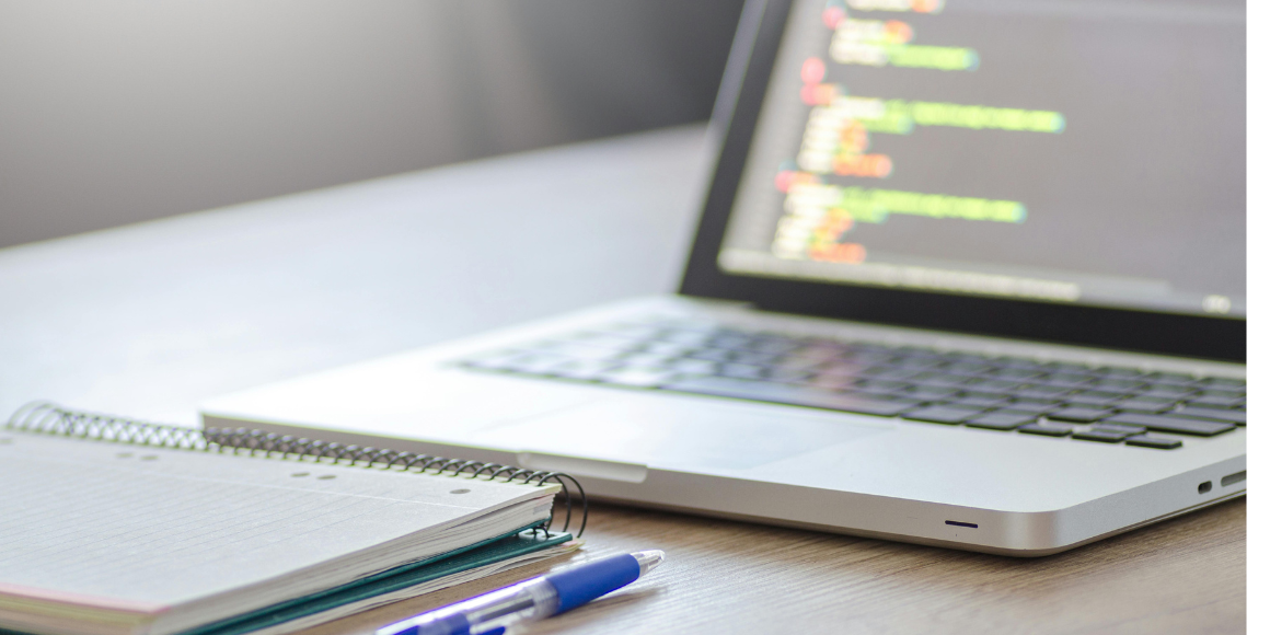 omnichannel ecommerce software planning in a laptop with a notebook and a pen on a desk.