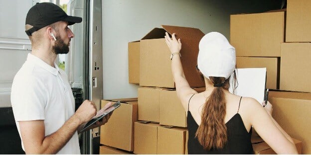 A man and woman organize boxes, coordinating inventory allocation to ensure balanced stock across channels.