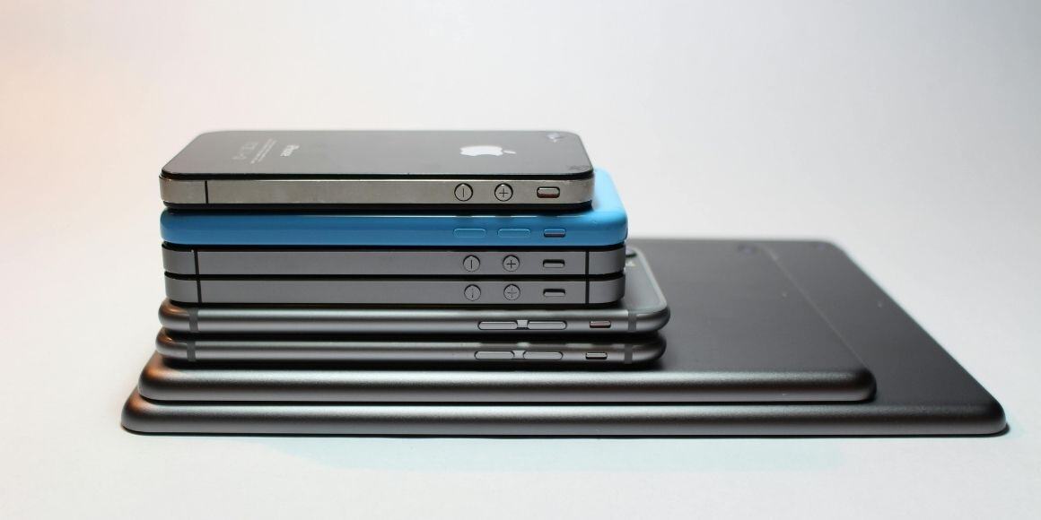 Pile of smartphones and tablets showcasing the need for an efficient order management system.